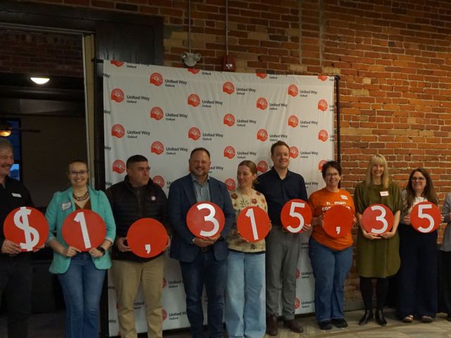 Group of event attendees stand holding numbers that make the number $1,315,358