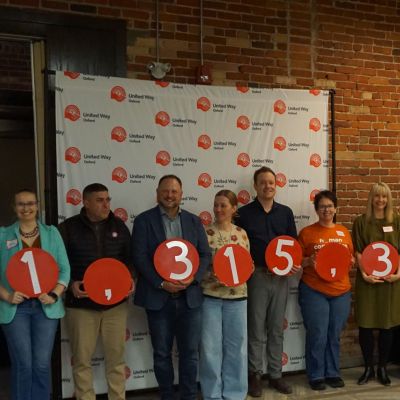 Group of event attendees stand holding numbers that make the number $1,315,358